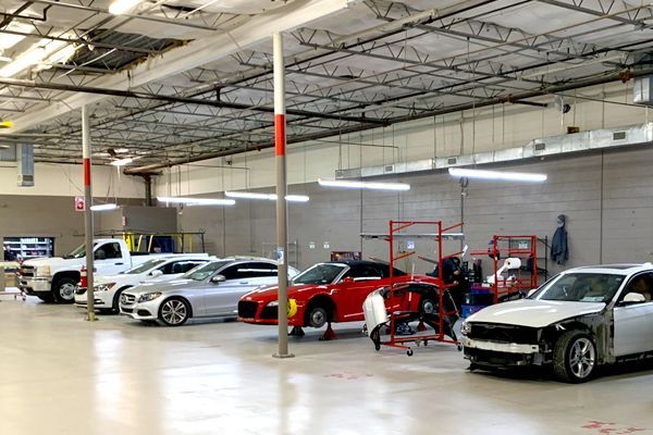 A row of cars are parked in a garage.