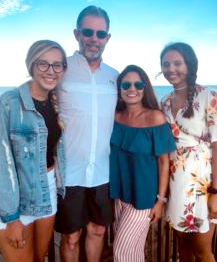 A group of people are posing for a picture on the beach.