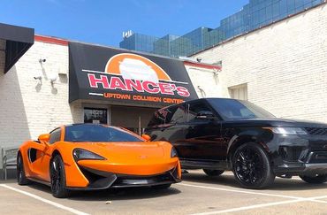 Two sports cars are parked in front of a building.