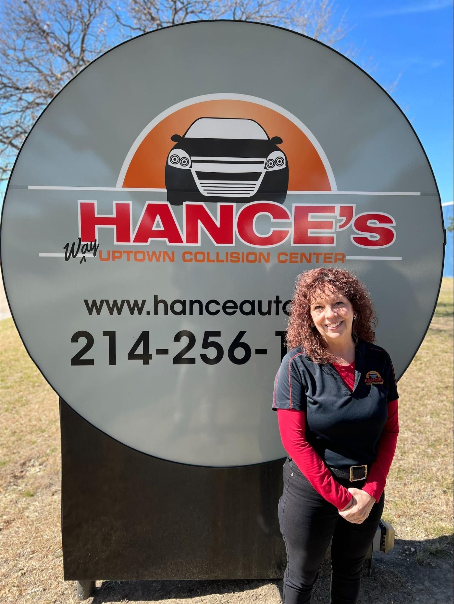 A woman is standing in front of a hance 's sign