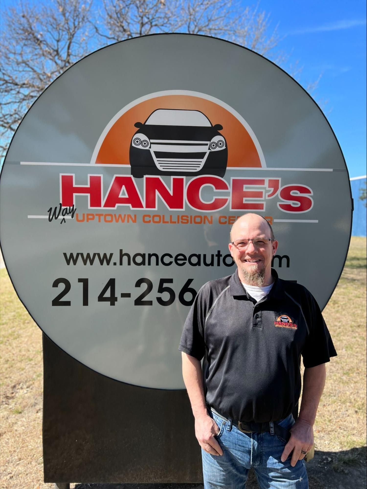 A man standing in front of a sign that says hance 's