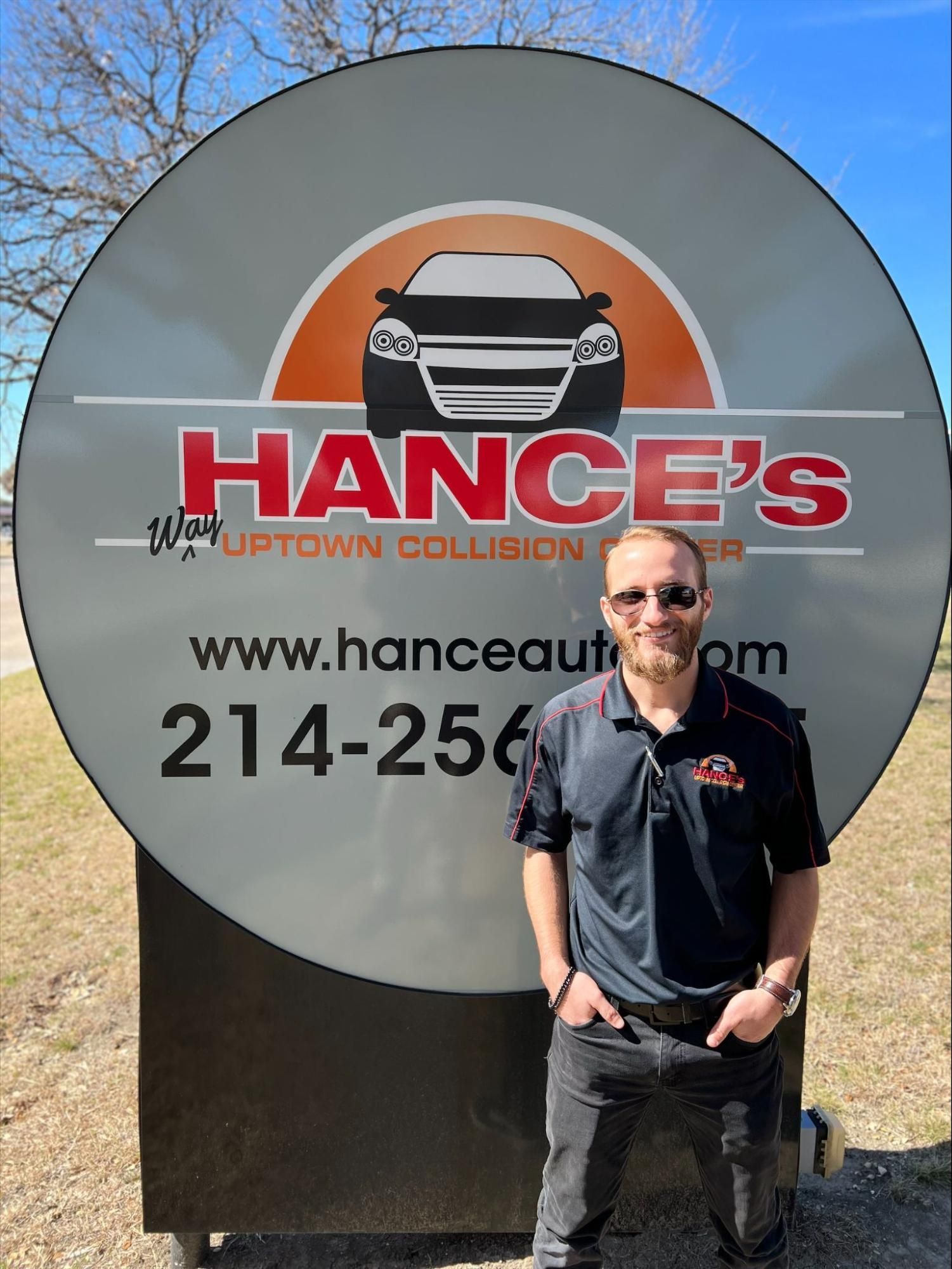 A man is standing in front of a sign that says hance 's