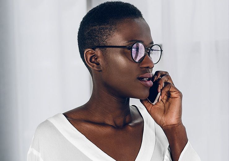 A woman wearing glasses is talking on a cell phone.