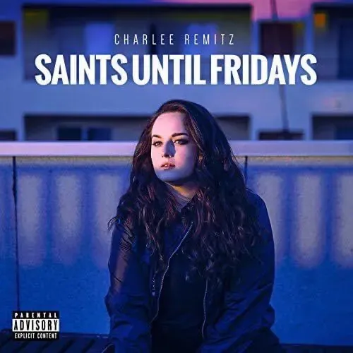 Charlee Remitz pictured with curly brown hair, red lipstick, and gold hoop earrings. Title 