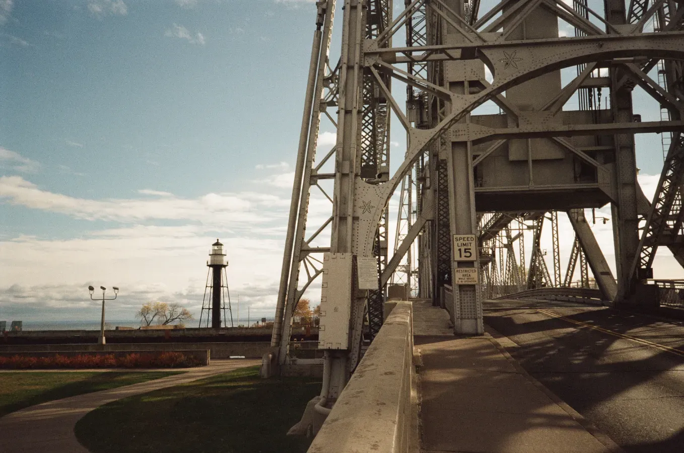 Duluth Harbor South Breakwater Inlet with a lighthouse in the background, a walkway, and a cloudy sky.