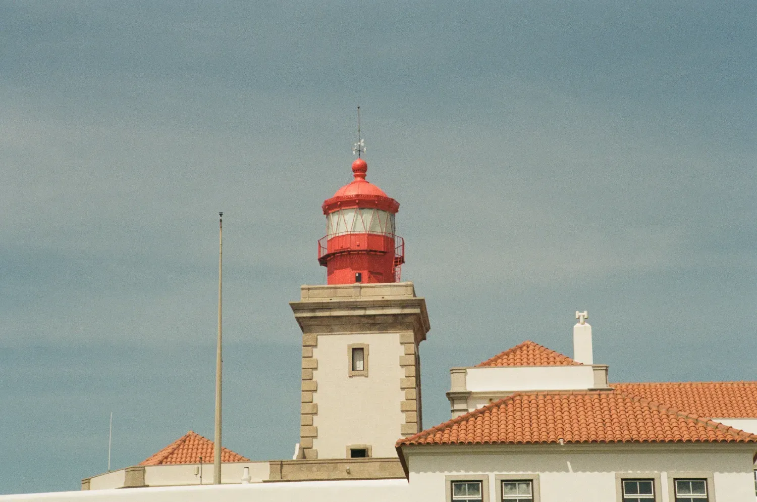 the top of the Farol do Cabo da Roca lighthouse against a blue sky