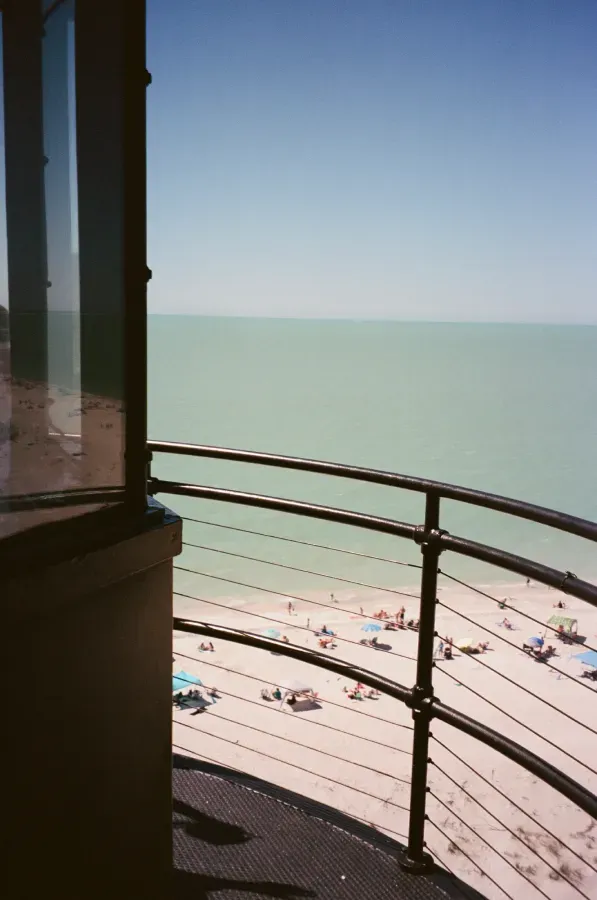 View from the catwalk overlooking Gasparilla Island beach with people, a sea, and a clear sky.