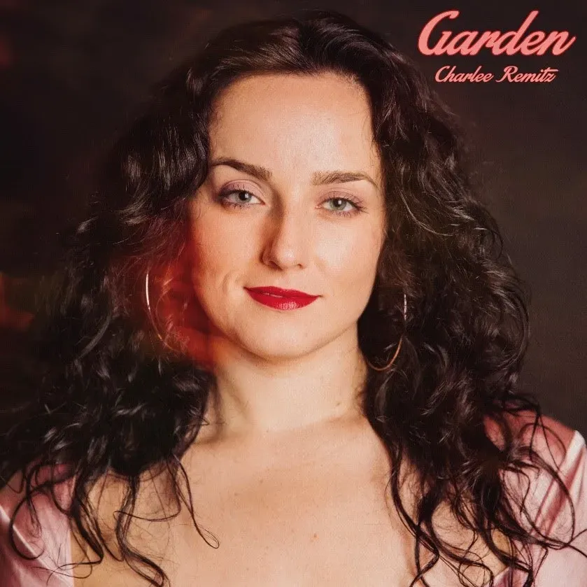 Woman with curly dark hair and red lipstick, the album cover for "Garden" by Charlee Remitz.