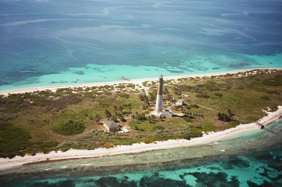 Island with Loggerhead Key lighthouse, white sand beaches, and turquoise water.
