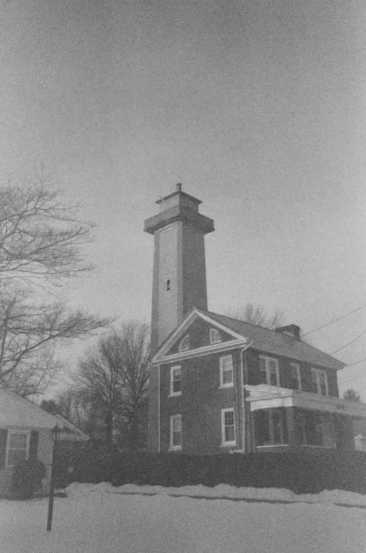 Marcus Hook Range attached to a two-story house, surrounded by trees and snow, captured in a black and white photograph
