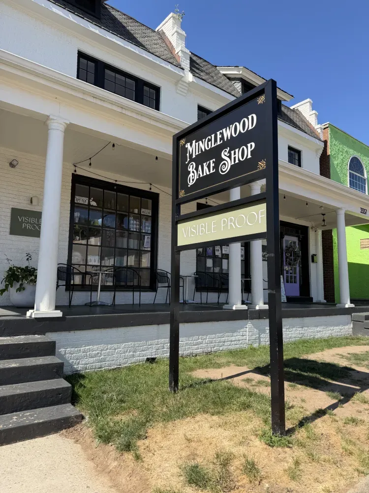 Nunezwood Bake Shop sign outside a white storefront with black-trim windows and steps.