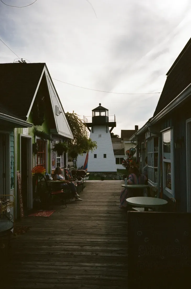 Wooden boardwalk leads to the Olcott lighthouse under a cloudy sky