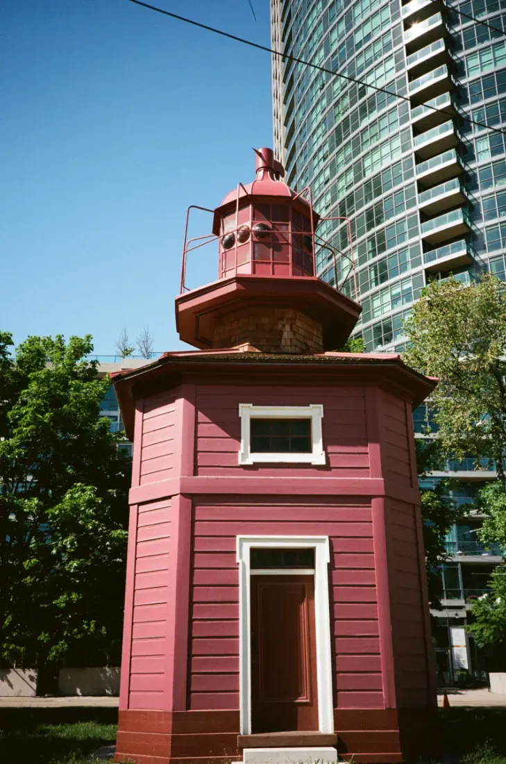Port Dalhousie lighthouse with green door and base against blue sky