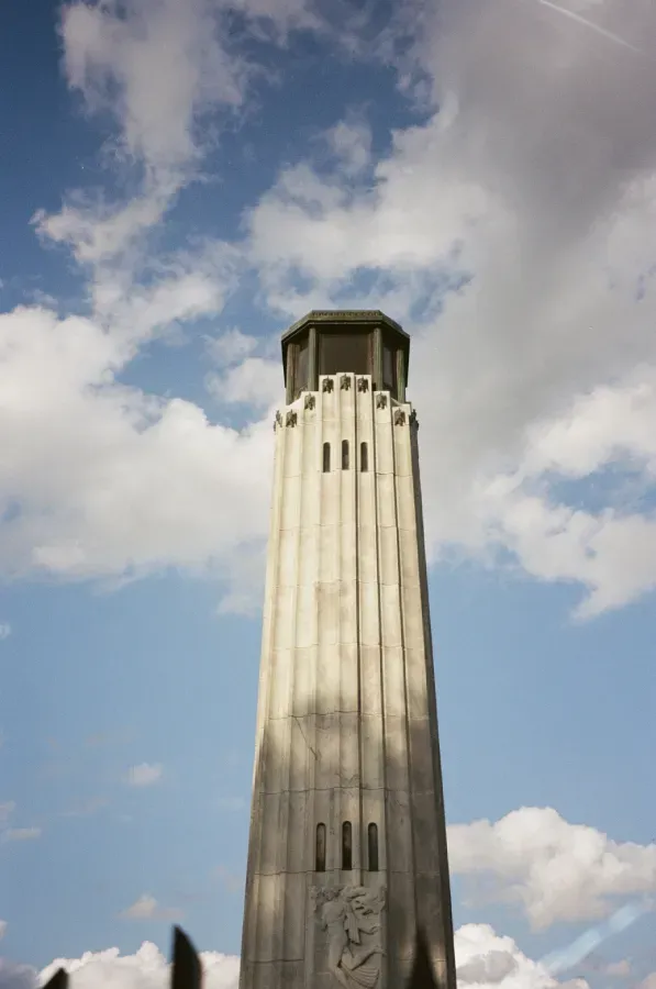 Film photograph of William Livingstone Memorial rises into a blue sky with fluffy clouds.