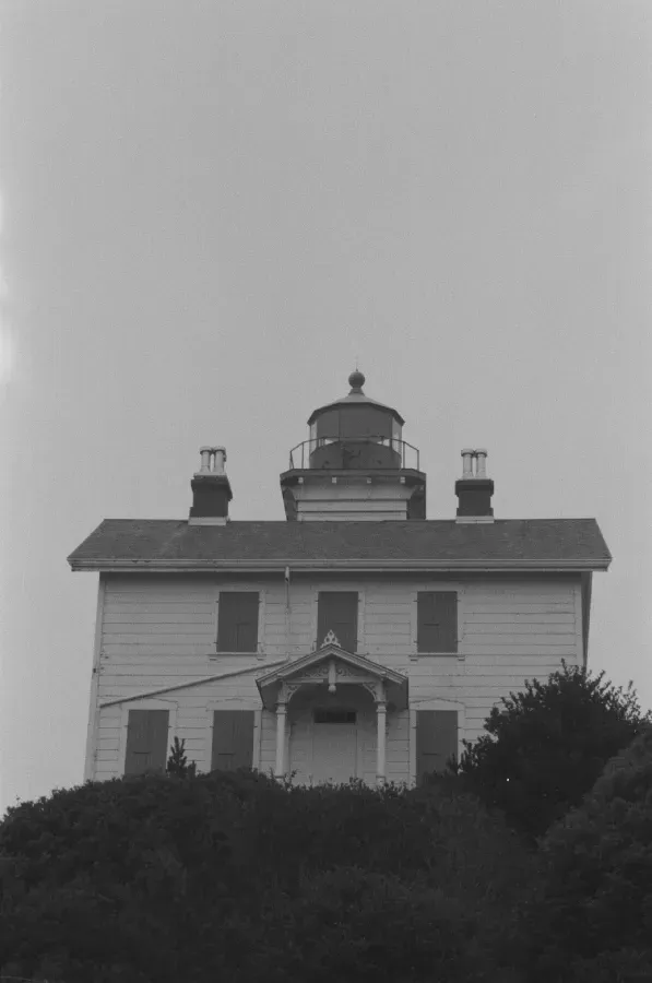 a black and white film photograph of Yaquina Bay lighthouse in Oregon USA