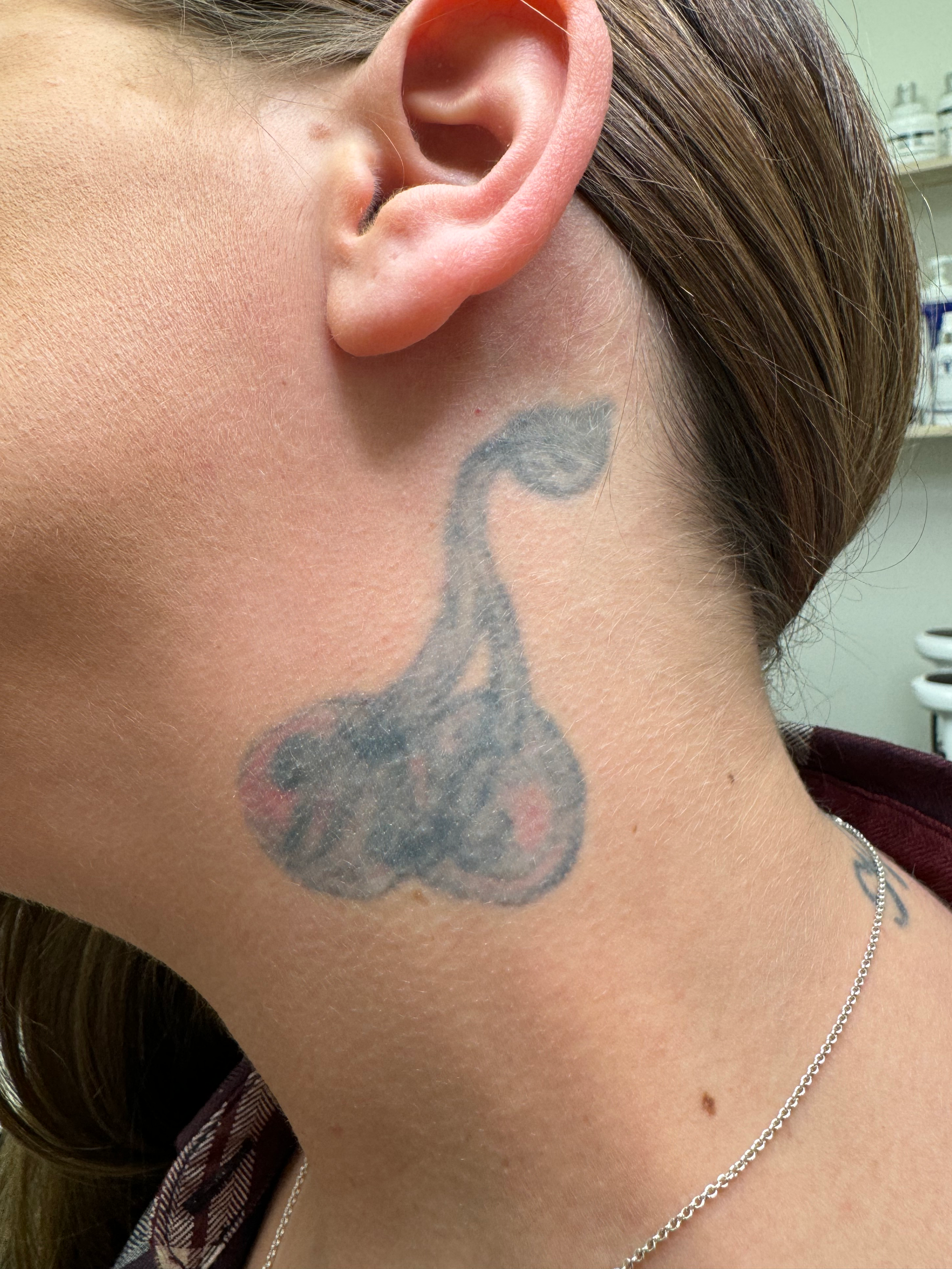 A woman with a tattoo on her neck and ear.