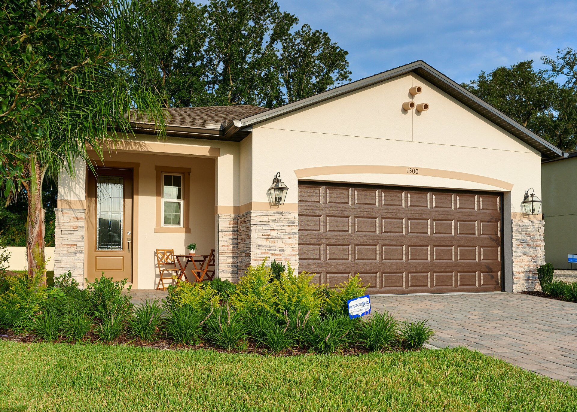 Arisha Enclave single-family home exterior with garage, stone accents, and landscaping.