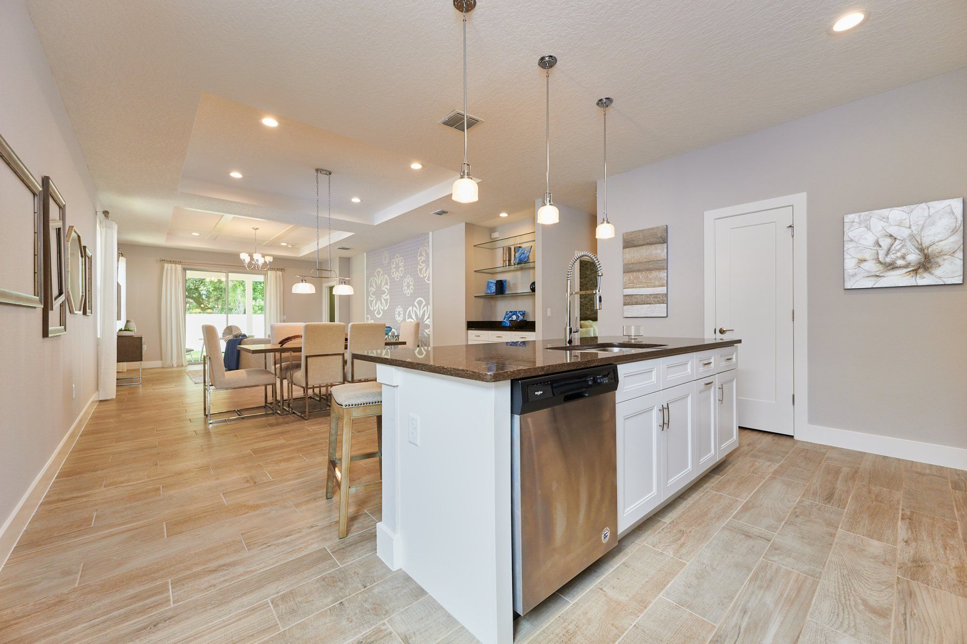 Arisha Enclave kitchen with white cabinetry, island seating, and recessed lighting.