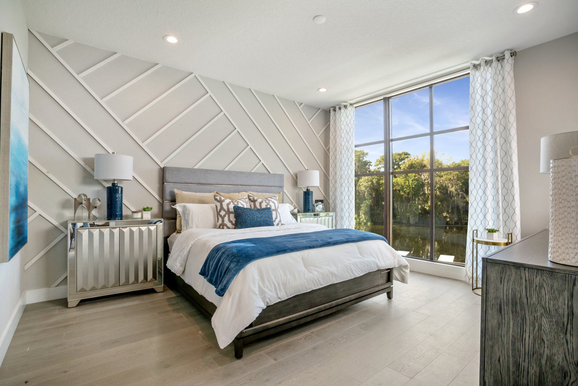 Lake Killarney Townhomes bedroom with upholstered bed and large window lighting.