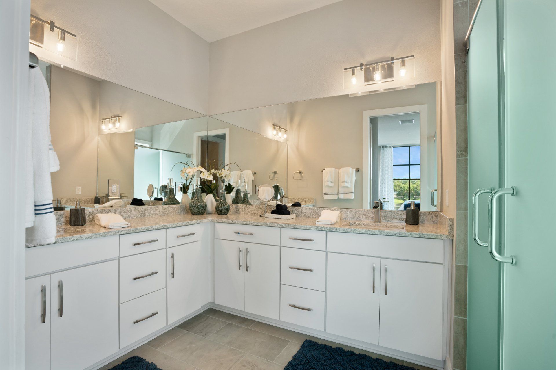 Lake Killarney Townhomes bathroom with double vanity, decorative mirrors, and glass shower.