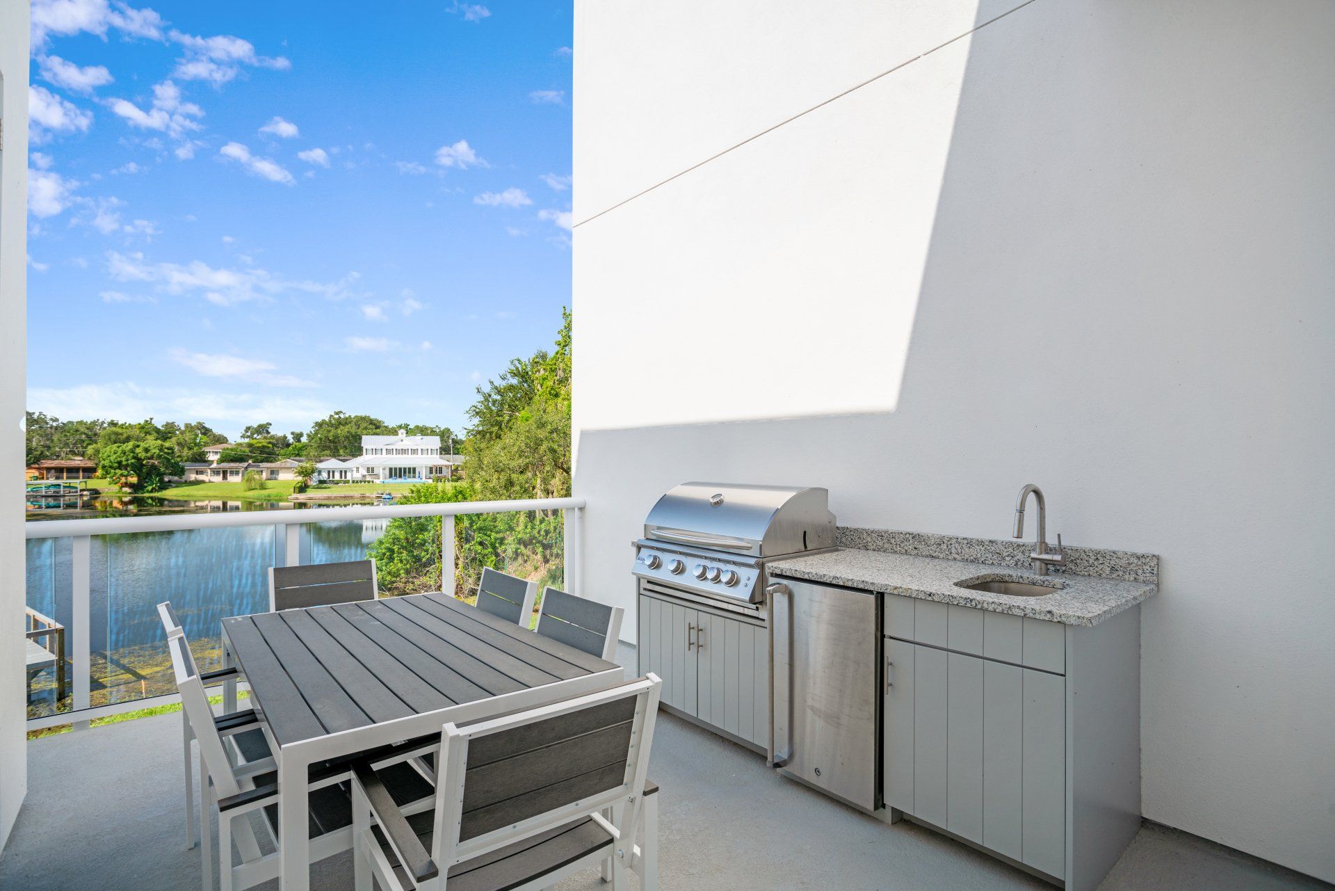 Lake Killarney townhome balcony overlooking community grounds and blue sky.