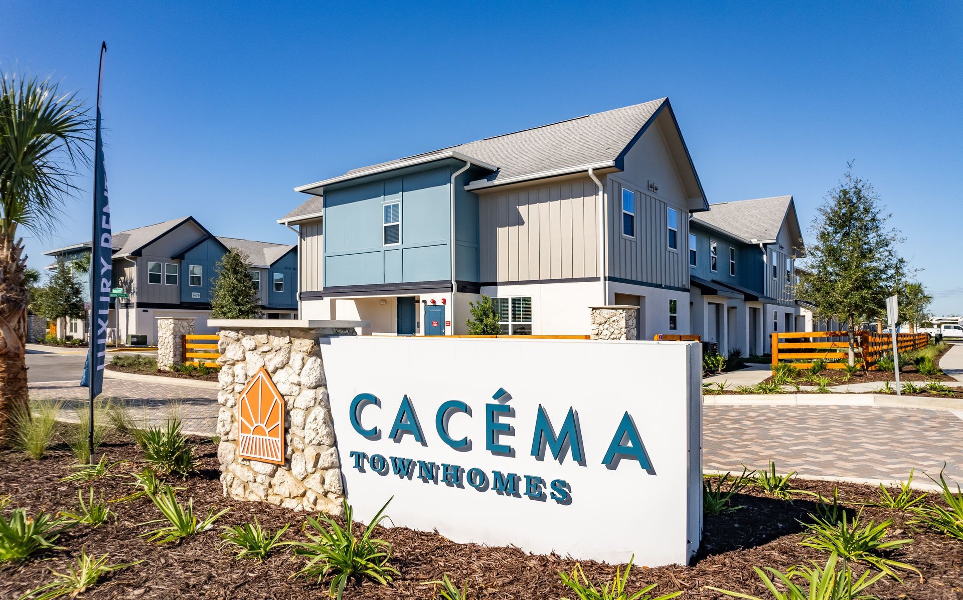 Cacéma Townhomes entrance sign with landscaped grounds and community buildings.