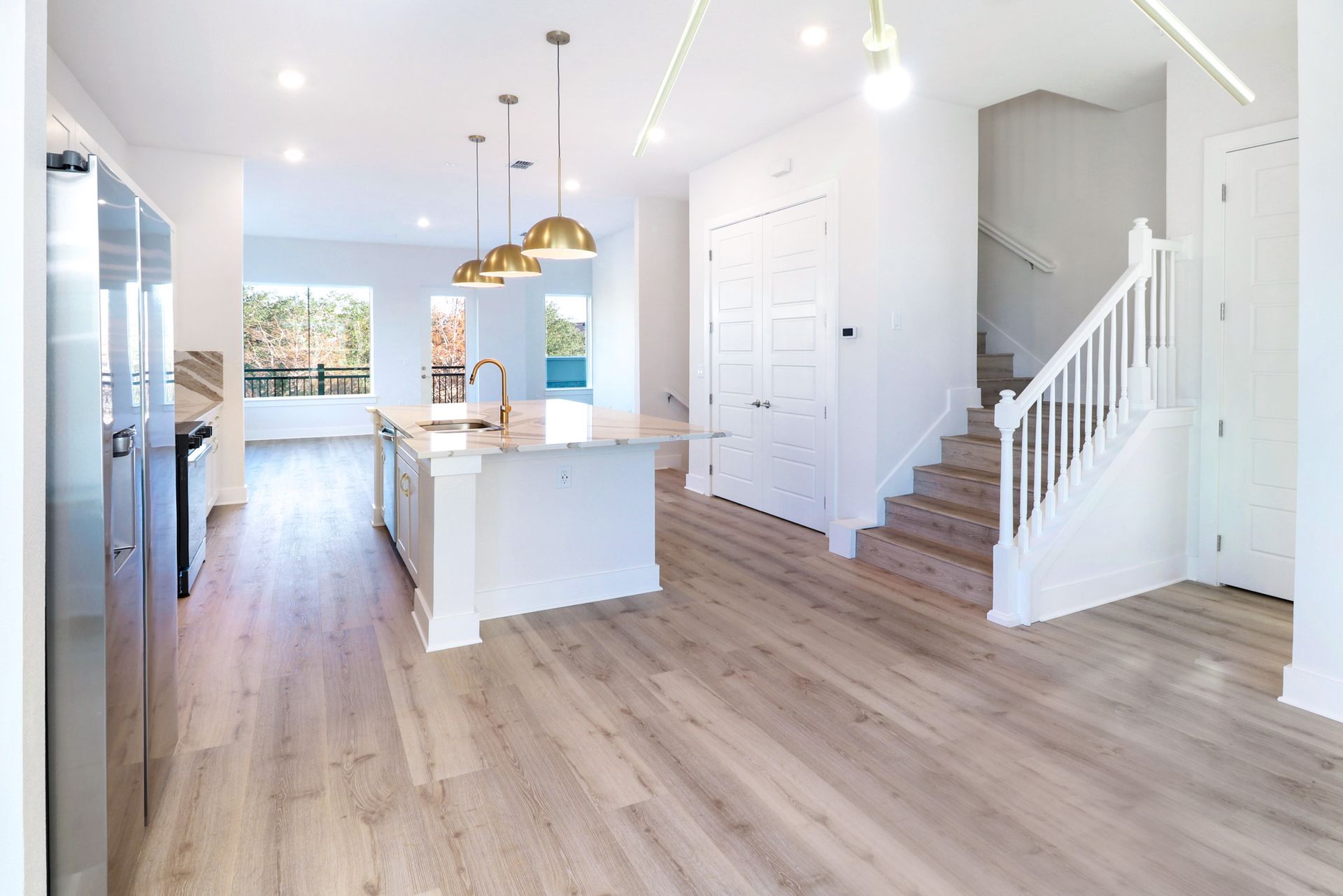 Bright kitchen with pendant lighting, island seating, and white cabinetry.