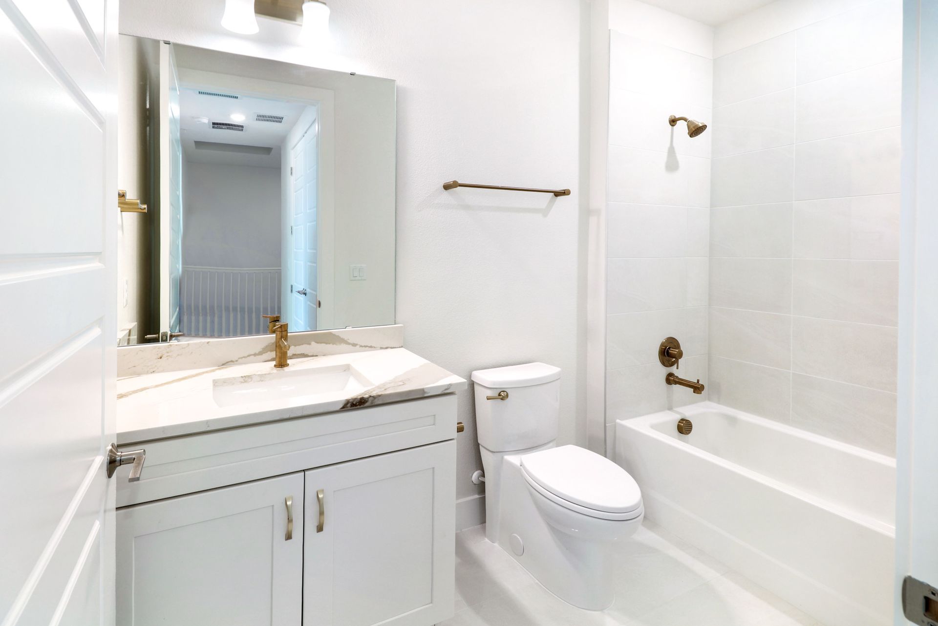 Modern bathroom with walk-in glass shower, tile walls, and clean white finishes.