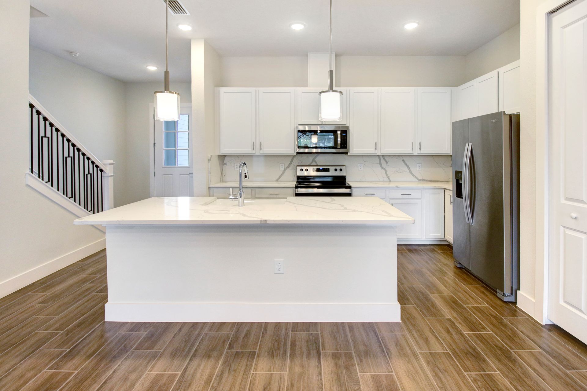 Brentwood Landing kitchen with center island, stainless appliances, and wood flooring.