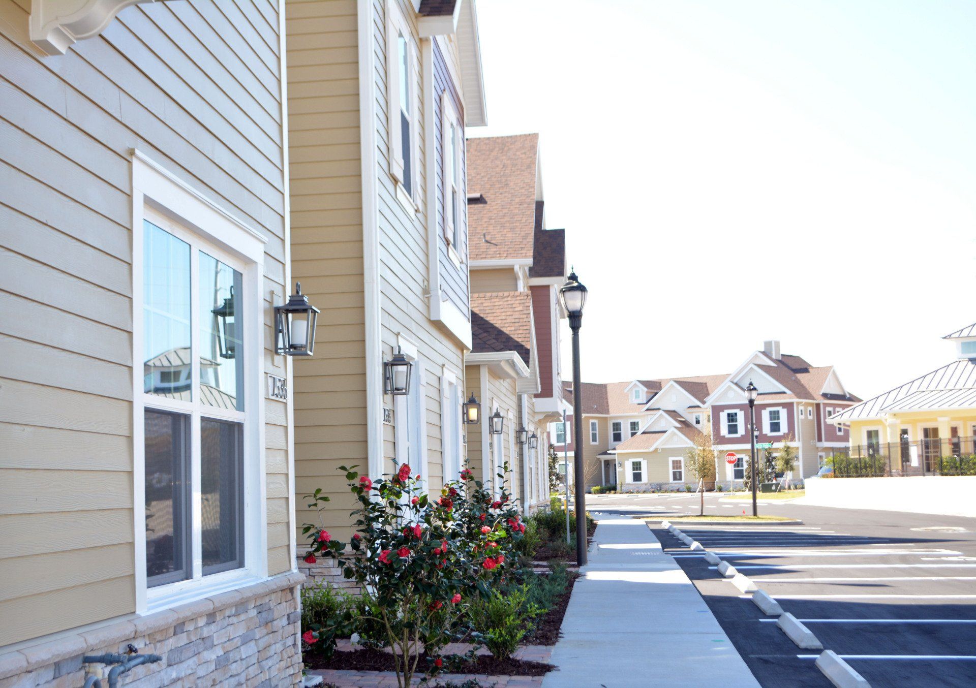 Townhome community with paved sidewalks, landscaping, and multi-story homes.