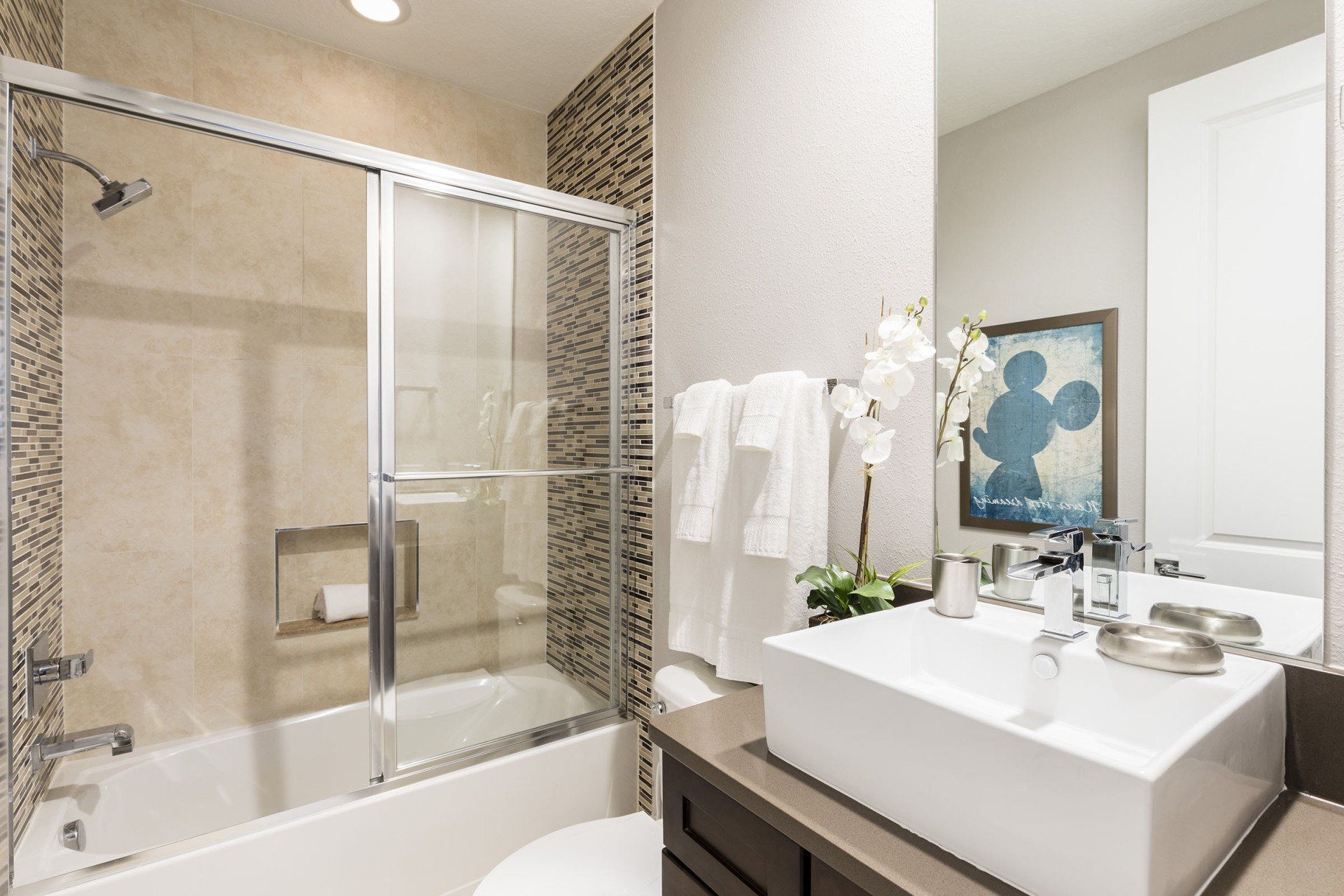 Summerville Resort bathroom with walk-in glass shower and tile walls.
