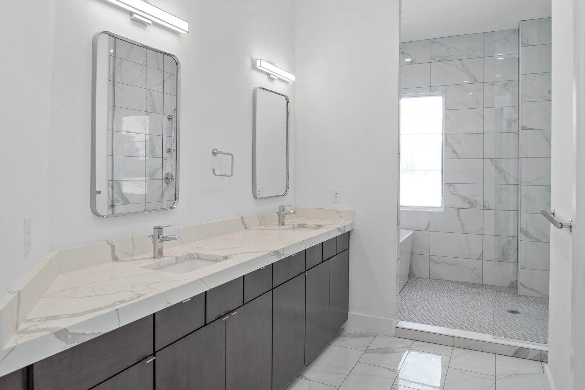 Bathroom with walk-in shower, floor-to-ceiling tile, and minimalist fixtures