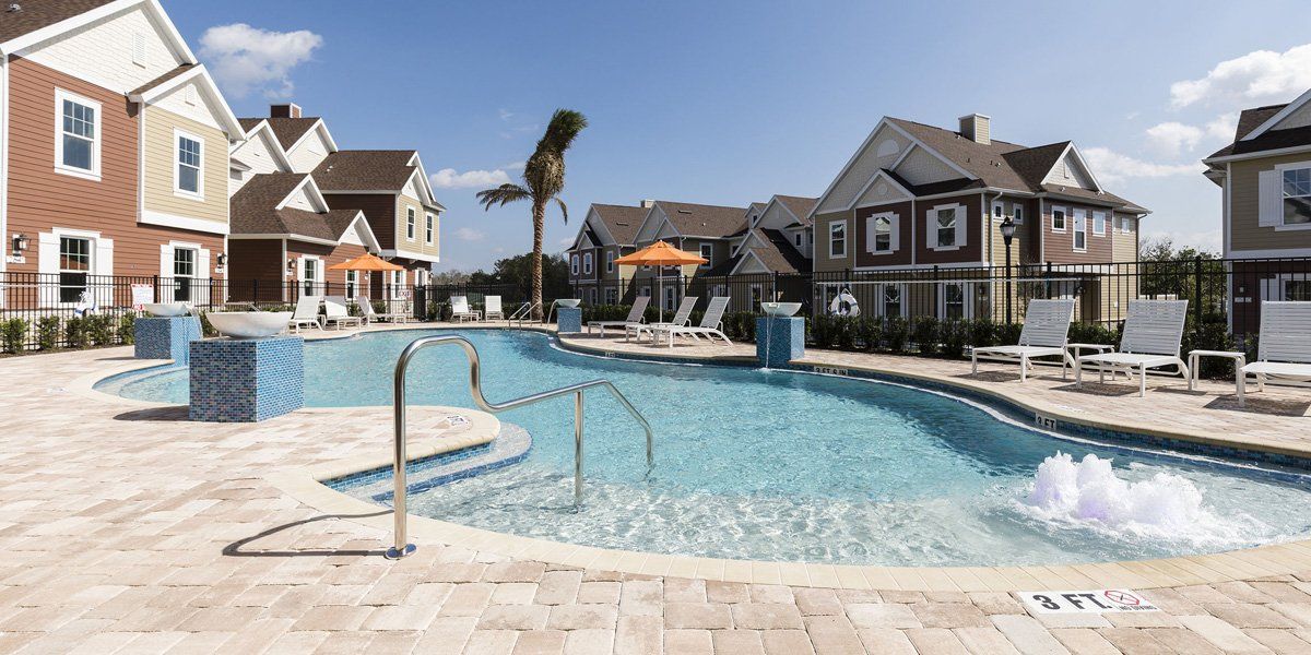 Summerville Resort townhomes surrounding a large resort-style pool with palm trees and seating areas
