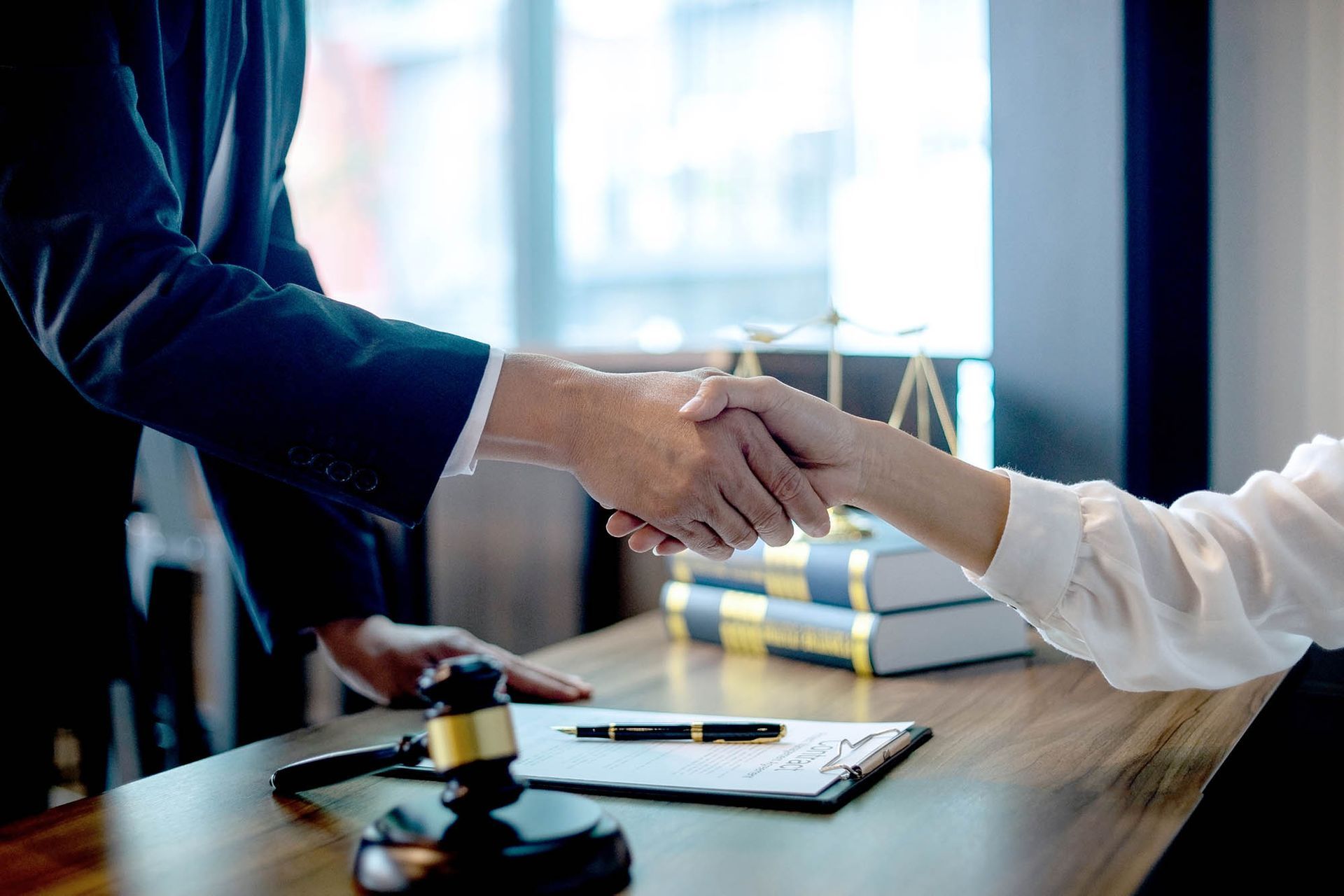 Lawyer and client shaking hands during a criminal defense meeting