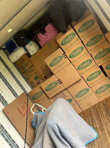 Packed moving truck with stacked cardboard boxes and a chair inside