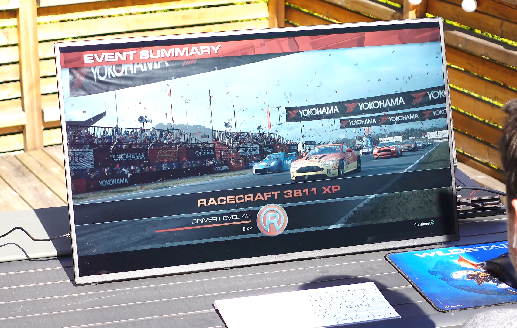 A tv screen shows a race and says event summary