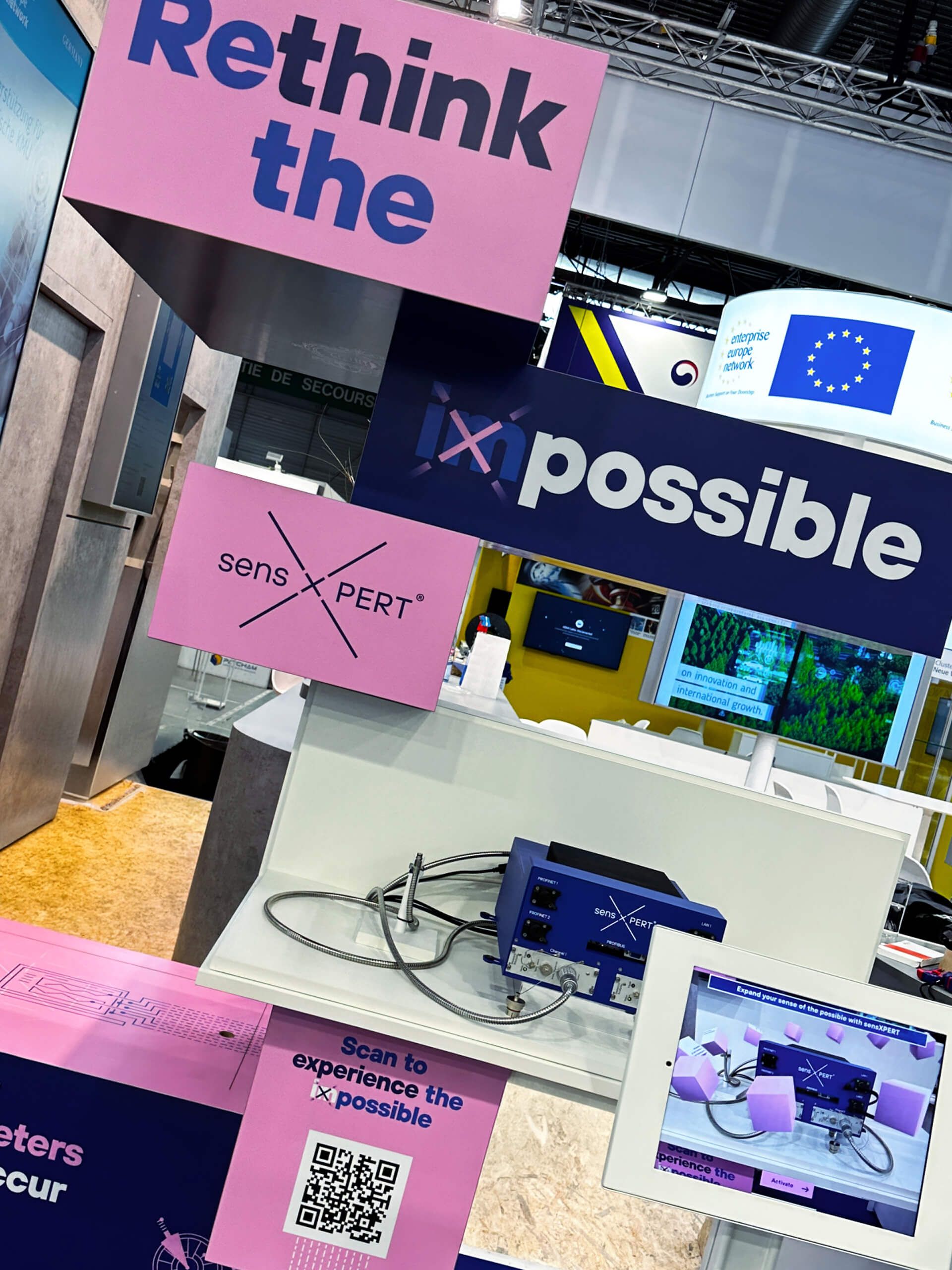 A booth at an exhibition features signage reading