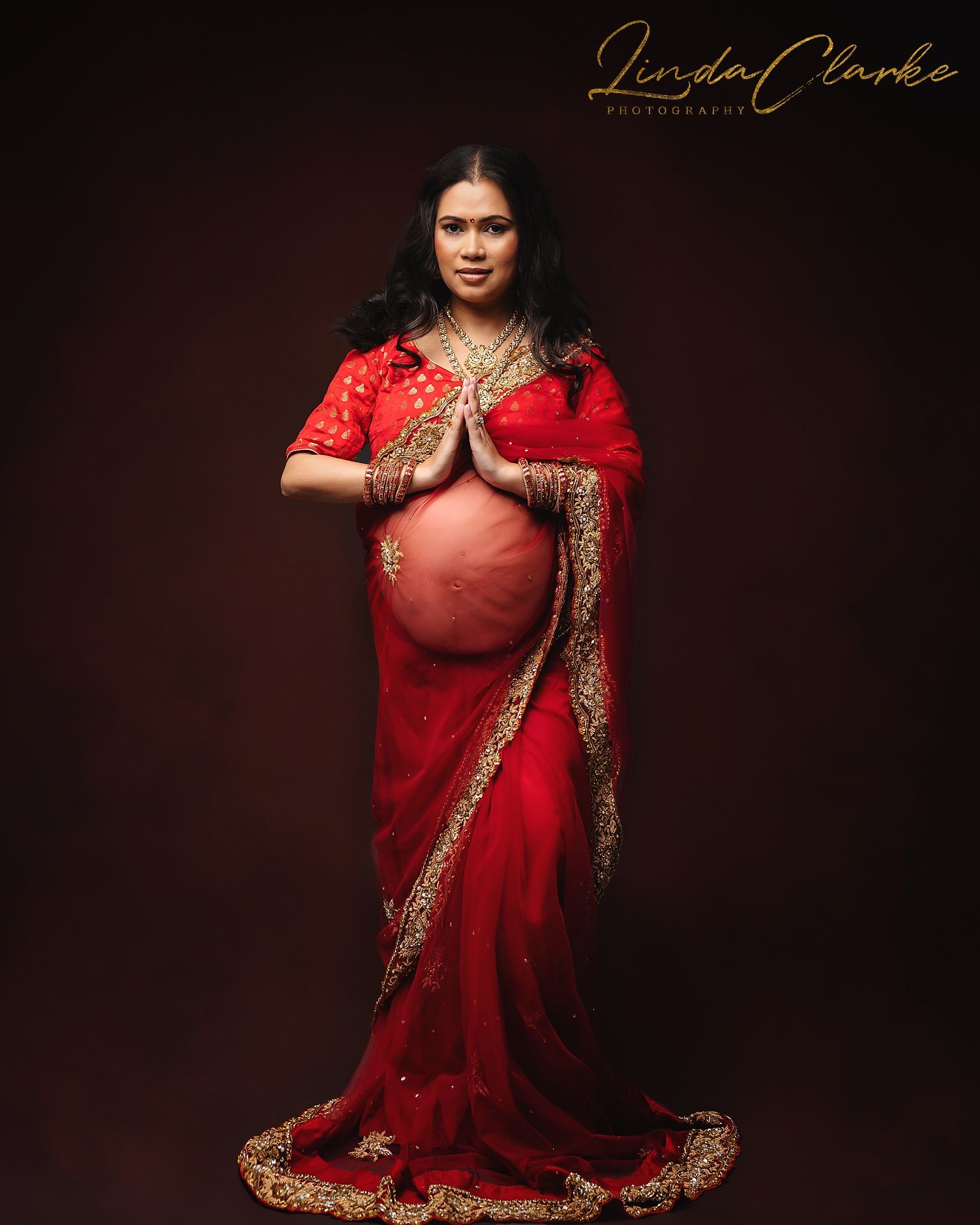 Pregnant woman posing in a red dress