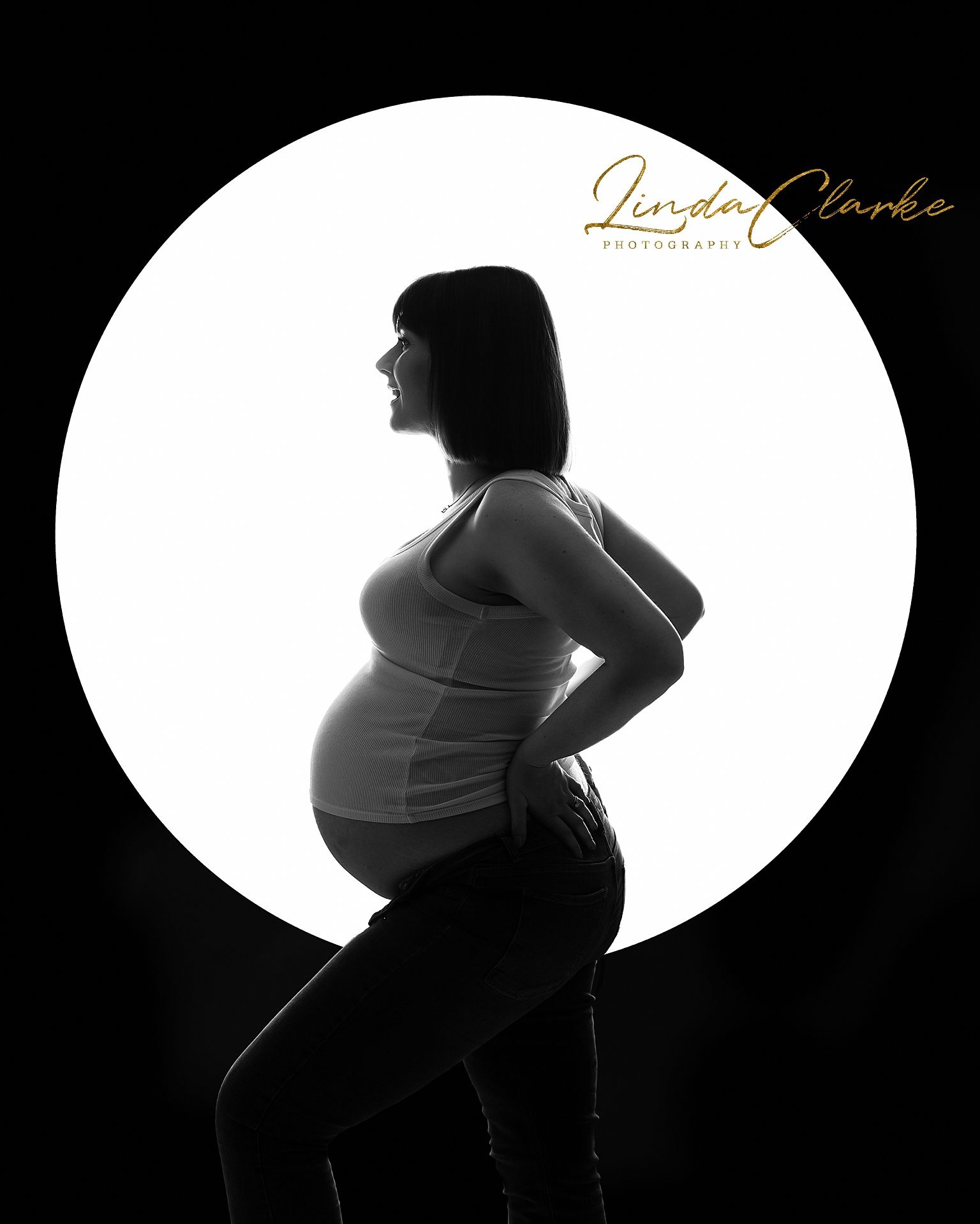 Black and white photo of a pregnant woman, photographed from the side.