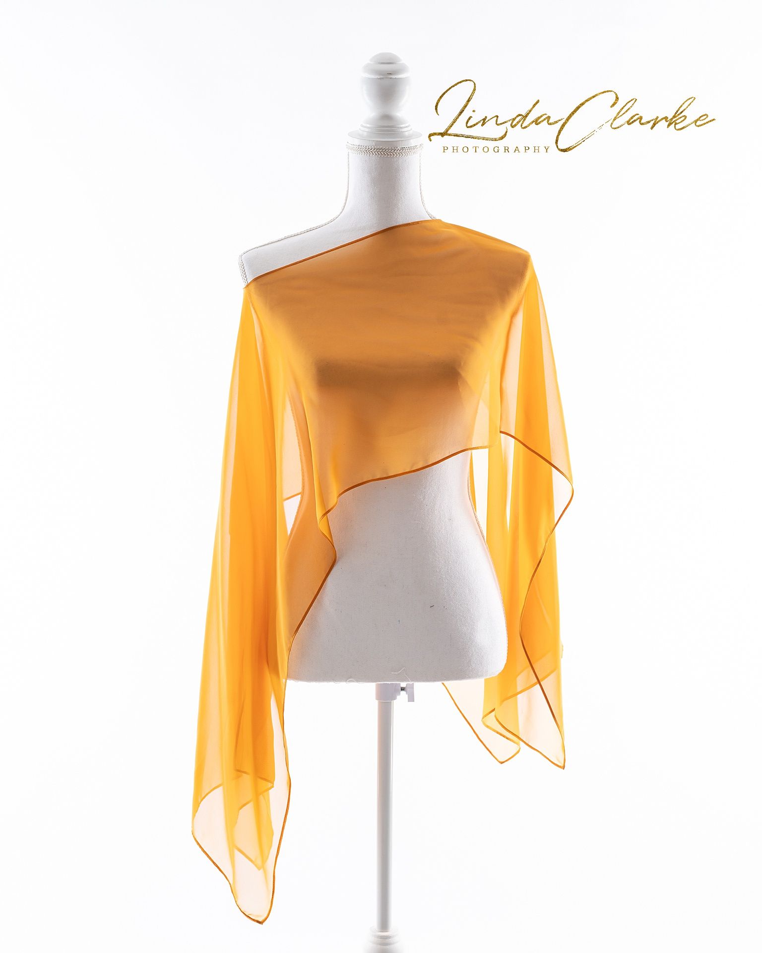 gold dress on a white mannequin with a white background and gold logo on the top right