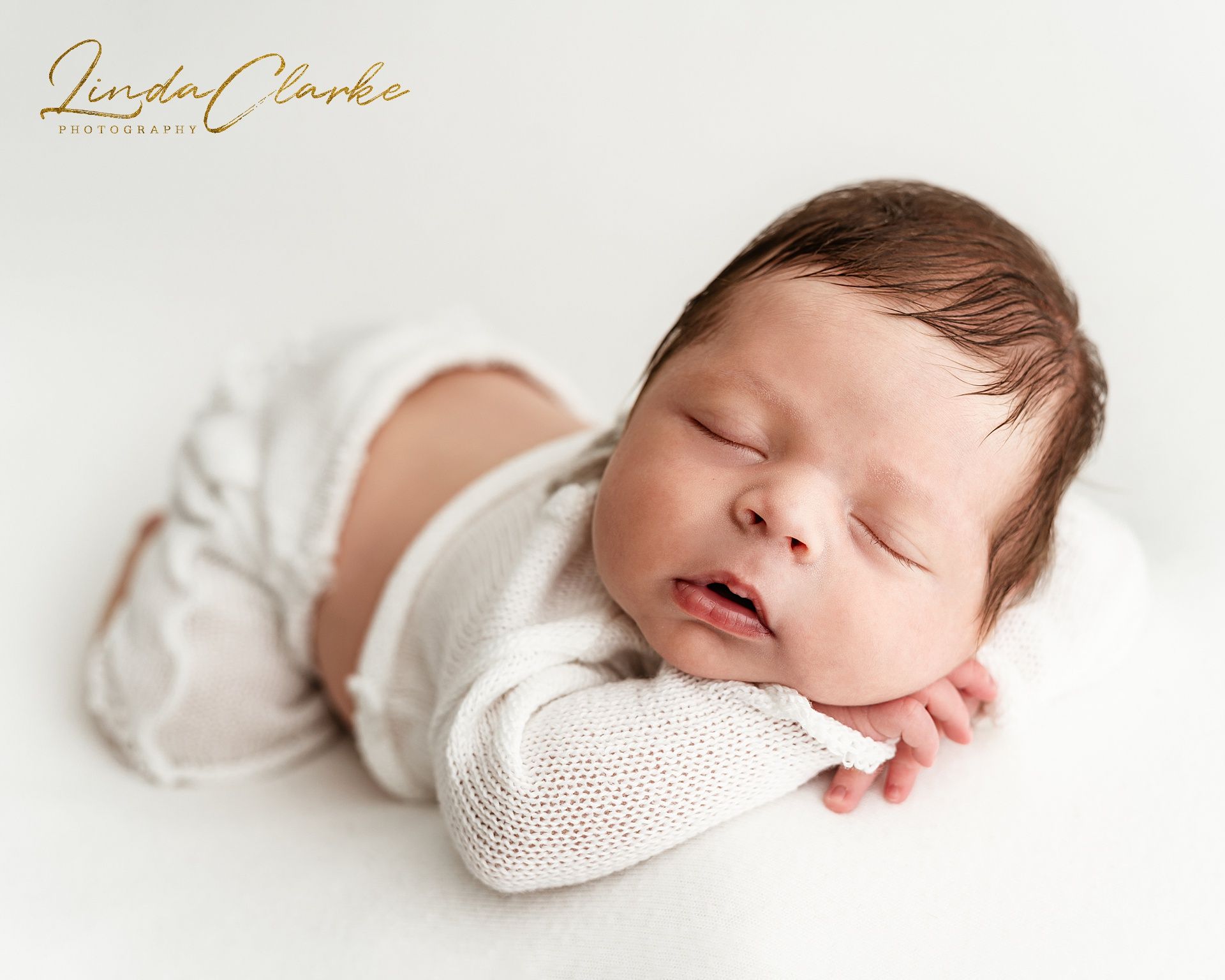 Sleeping newborn baby photographed in soft neutral tones during a calm, baby-led newborn photography session in a Dublin studio.