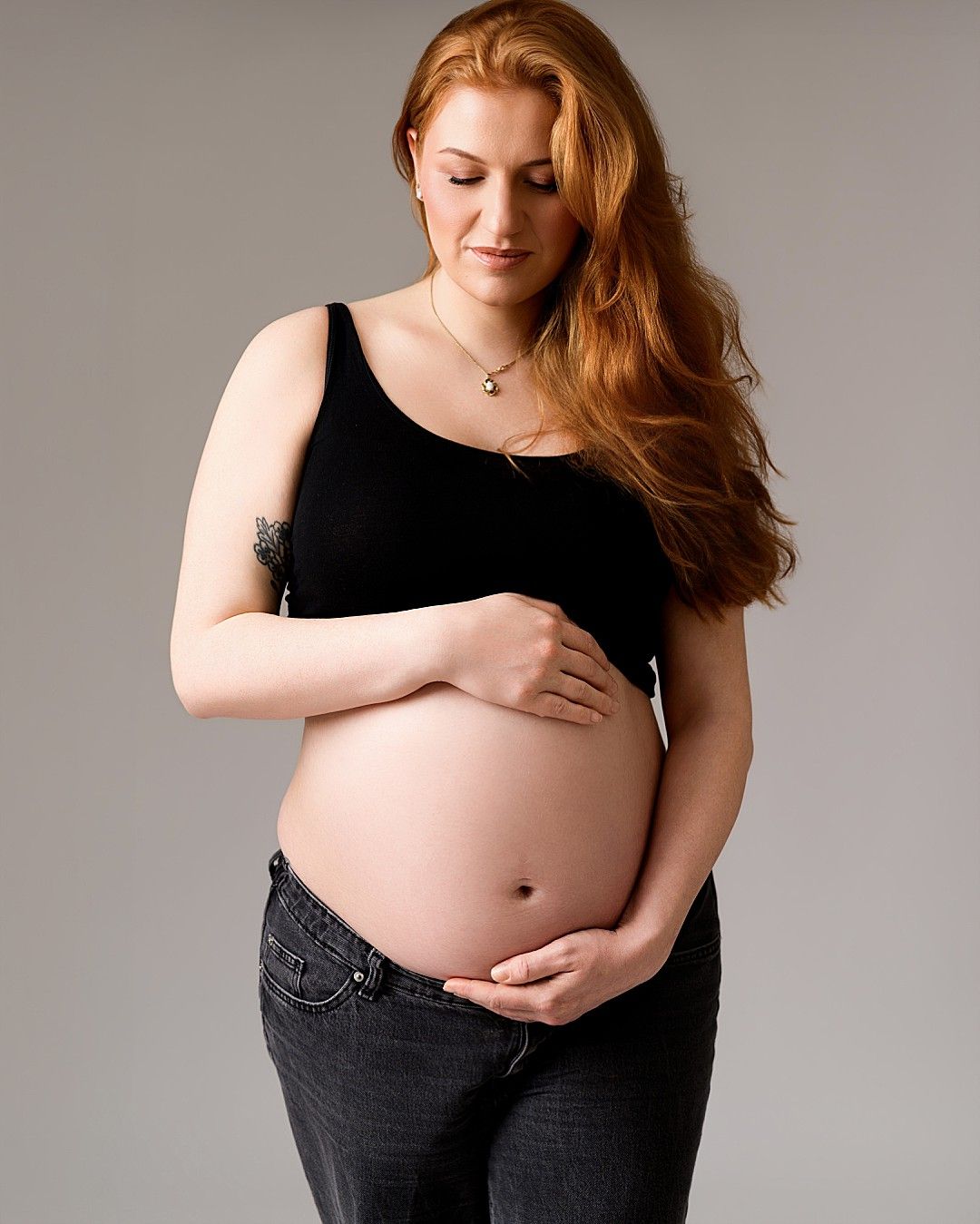 Timeless studio maternity portrait of an expectant mother wearing a black bodysuit during a maternity photography session in Dublin.