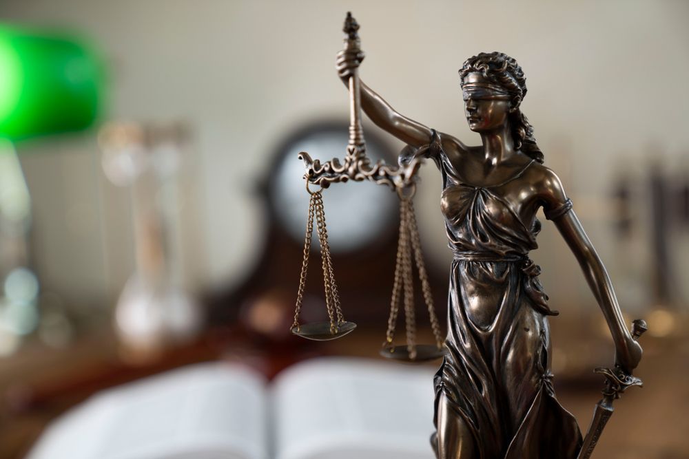 A Statue Of Lady Justice Holding Scales And A Sword — SJP Law In Maleny, QLD