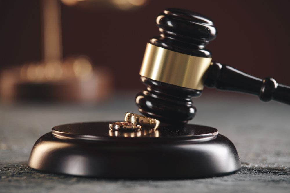 A Close Up Of A Judge's Gavel With A Pair Of Wedding Rings On It — SJP Law In Maroochydore, QLD