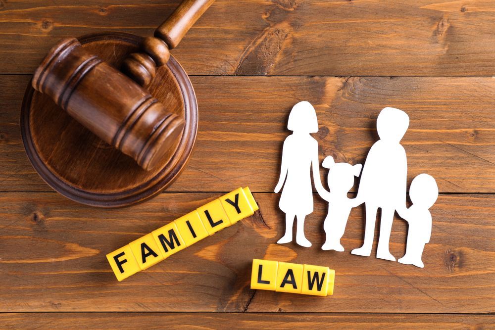 Wooden Judge's Gavel Beside Paper Cutouts Of A Family — SJP Law In Maroochydore, QLD