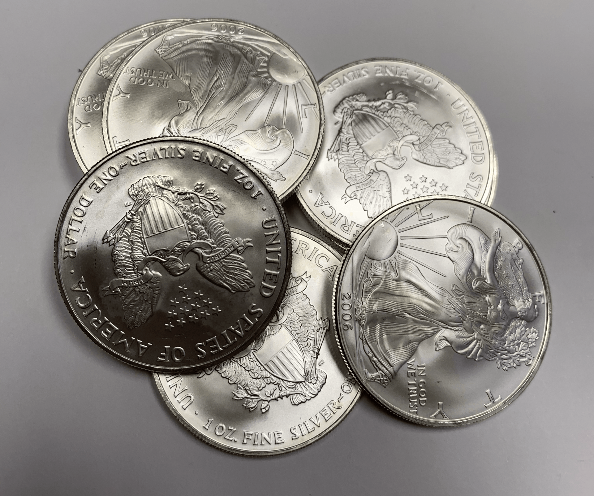 Five silver commemorative coins overlapping on a gray background, each with detailed wildlife and landscape designs