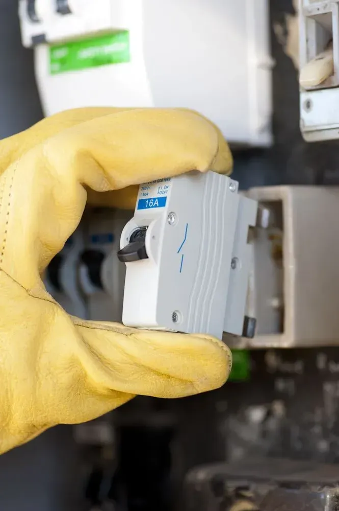 Gloved Hand Holding and Installing a Circuit Breaker — KACE Electrical Solutions In Ramsay, QLD