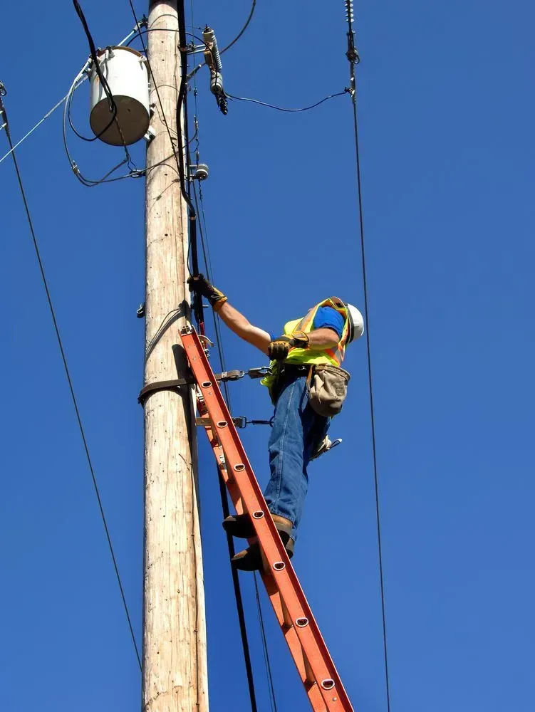 Lineman in Safety Gear on Ladder Working on a Utility Pole — KACE Electrical Solutions In Ramsay, QLD