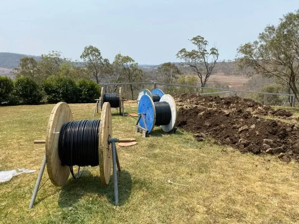 Cable Spools on Grass Near a Dirt Pile — KACE Electrical Solutions In Ramsay, QLD