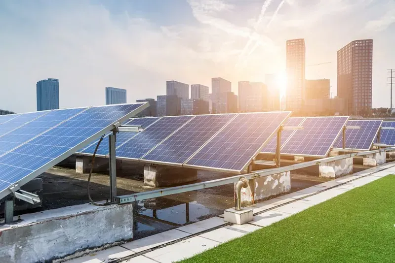 Solar Panels on a Rooftop With a City Skyline in the Background — KACE Electrical Solutions In Toowoomba, QLD